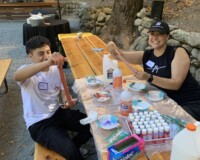 Two people smiling while working at a craft table