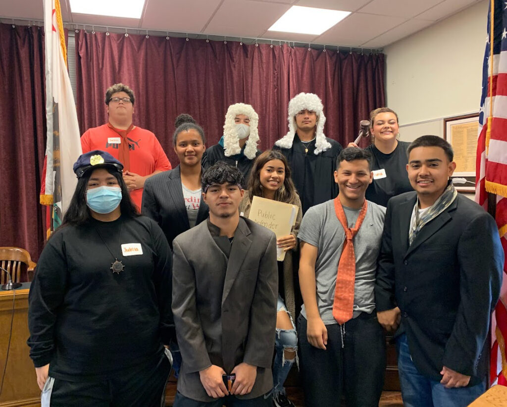 Group of kids on a field trip dressed as judges and lawyers posing for a photo