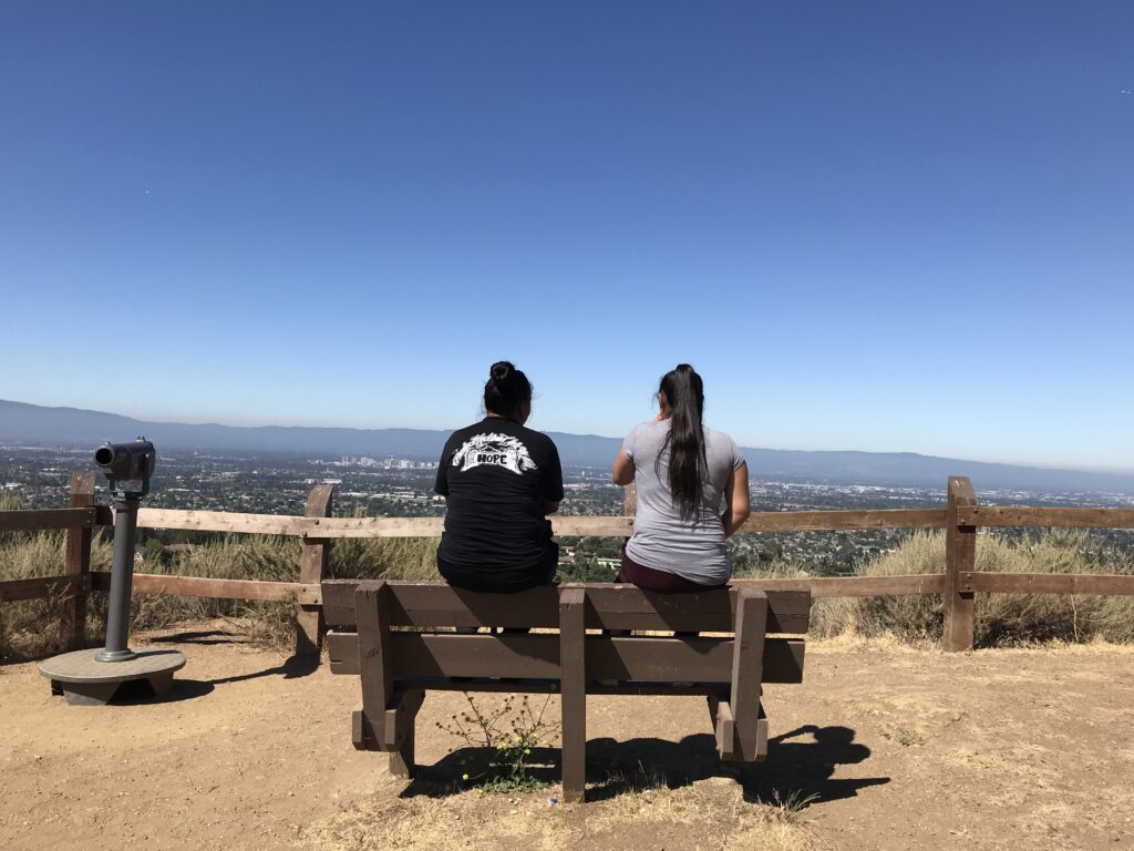 Two kids sitting on a park bench