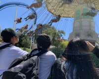 Three youth looking up at a carnival ride